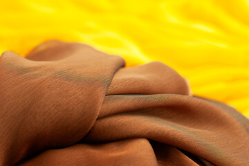 Silk fabric in yellow and brown. Silk fabric close up. Textile in the form of silk and organza.