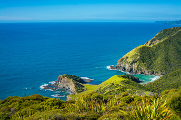 Looking down at a stunning rocky coastline of Cape Reinga. Turquoise water of Tasman Sea under...