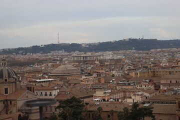 Obraz premium ROME, ITALY - February 05, 2022: Panoramic view around the Colosseum in city of Rome, Italy. Cold and gray sky in the background. Macro photography of the green parks with the old buildings.