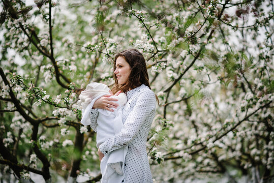 Mom with child looking on the blossom tree.