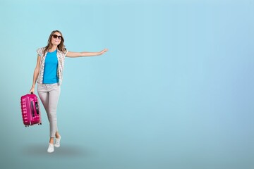 Happy american young woman tourist in casual outfit holding suitcase over blue pastel, traveling concept.