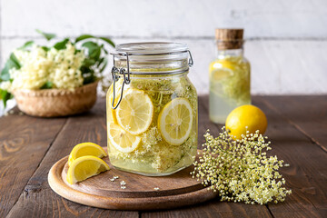 Elderberry infused water or syrup made with fresh flowers and lemons as basic ingredients. Wooden...