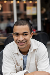 Obraz premium portrait of happy african american man sitting on summer terrace.