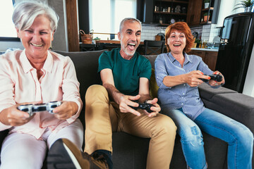 Obraz premium Group of middle age friends smiling happy playing video game at home.