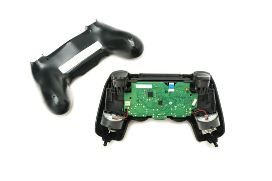 Controle de videogame aberto, com uma placa de circuito exposta. - Powered by Adobe