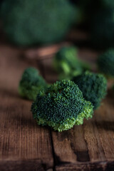 Fresh green broccoli on a wooden table on a dark background. Macro photography of green fresh vegetable broccoli for dietary and healthy nutrition. Organic products.