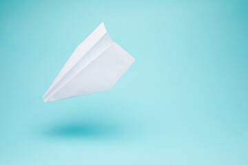 Paper plane origami isolated on blue background with copy space.