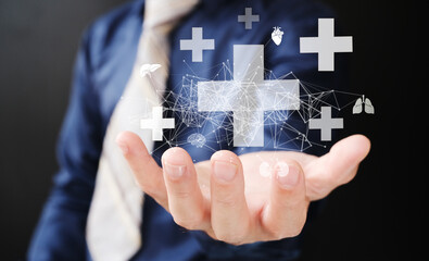 Businessman has virtual medical health care icons with medical and network connections in his hand. People's understanding of health care is growing, as is the medical health and life insurance. 