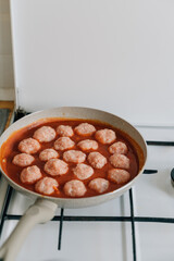 Meatballs cooking process in a pan at home. Beef, chicken and pork meat food recipe in tomato sauce 