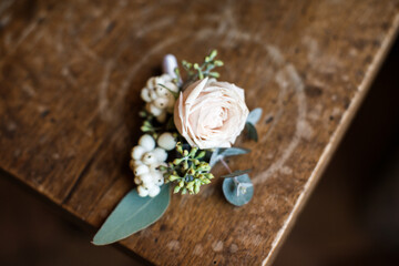 Fototapeta na wymiar Wedding rose boutonniere on a wooden table