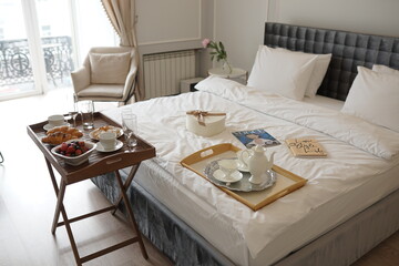 Delicious breakfast in bed. Coffee in bed on a white bed with buns, berries on a white