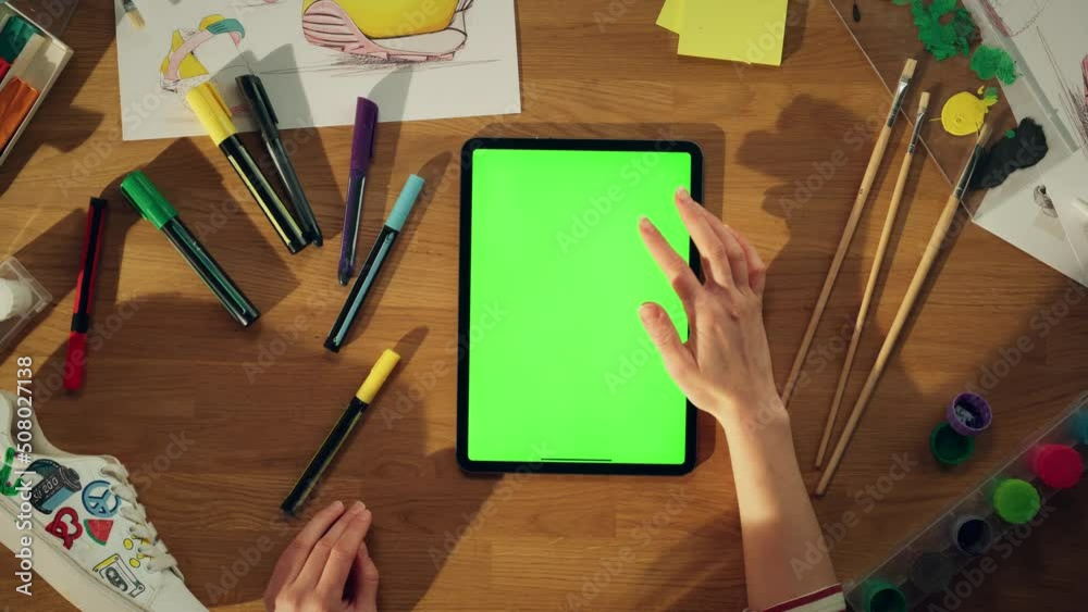 Aufkleber top close up view of millennial designer sitting at desk and working on green screen chroma key tabl
