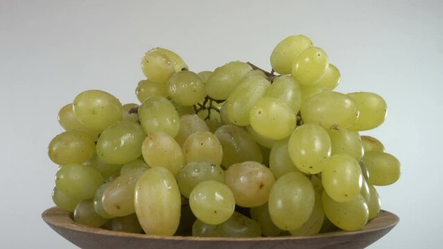 4K view of a bunch of green grapes in a plate rotate