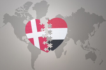 puzzle heart with the national flag of yemen and denmark on a world map background. Concept.