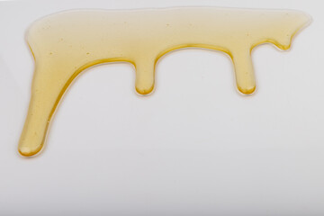 Honey flows. Drops of yellow syrup flow. Natural product and sweet drink. Isolated on white background.