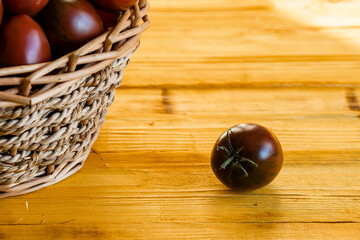 Ripe juicy black tomato on a wooden table