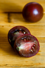 Ripe juicy black tomato on a wooden table