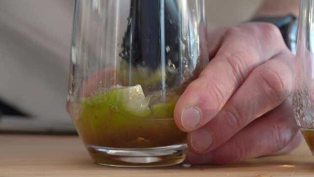 Man Mashing Lime On The Glass With A Muddler - Making Mojito. - close up