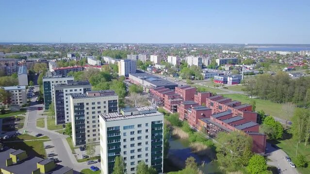 Aerial view of crowded residential district apartment buildings on a sunny summer day, renovated and insulated houses, colorful walls of the facade, wide angle drone shot moving backward