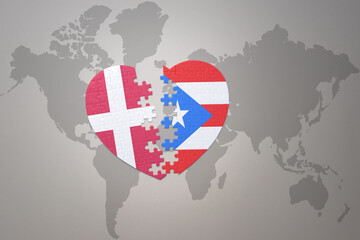 puzzle heart with the national flag of puerto rico and denmark on a world map background. Concept.