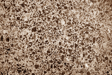 Cement with gravel stones surface in brown tone.