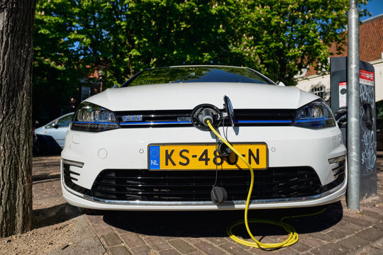 Volkswagen Golf GTE petrol-electric hybrid car being charged in the street