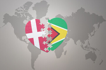 puzzle heart with the national flag of guyana and denmark on a world map background. Concept.