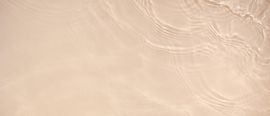 Abstract summer banner background Transparent beige clear water surface texture with ripples and splashes. Water waves in sunlight, copy space, top view. Cosmetics moisturizer micellar toner emulsion