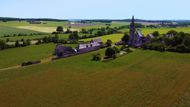 Poppies field in a typical countryside with a church in France
