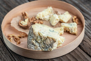 Danish blue cheese. Tasty blue cheese on a wooden background and burlap. Dorblu cheese pieces