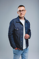 Live a rich life. Positive emotions. Portrait of a young attractive man in a white t-shirt and denim jacket. Men's clothing from the denim collection