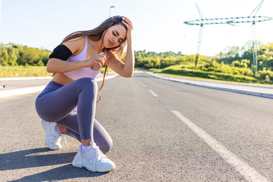 Young sports women having pain / injury during exercise and jogging in the nature. Female runner athlete leg injury and pain. Woman suffering from painful leg while running in the park.