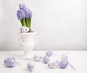Easter eggs and Lilac hyacinth in a vase, spring still life, copy space