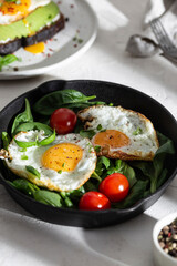 Breakfast with fried eggs and vegetables in a pan