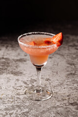 Red cocktail in glass on black background