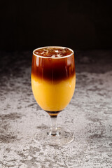 Cocktail with half of coffee and water in black background
