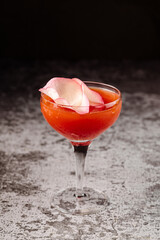 Red cocktail in glass on black background