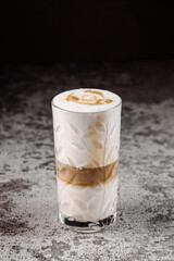 Tasty coffee latte in glass on black background