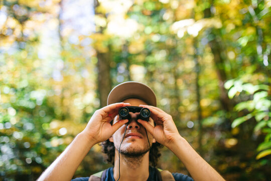 Hiker observing forest in binoculars