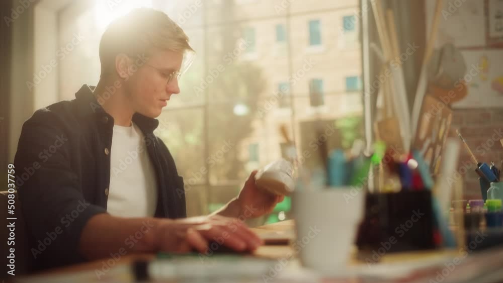 Poster male artist examining shoes while creating design for it. hipster male is customising shoes by his o