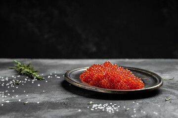 Delicious red caviar in vintage plate on dark background. banner, menu, recipe. selective focus, place for text