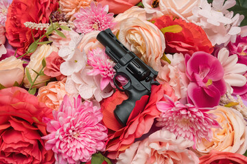 Colorful floral summer arrangement with black gun and pink and red flowers. Bright and trendy feminine concept.