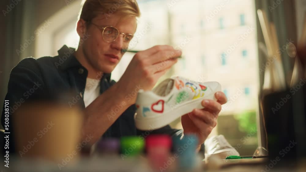 Poster cinematic portrait view of the male designer examining shoes while drawing on it. hipster man is cus