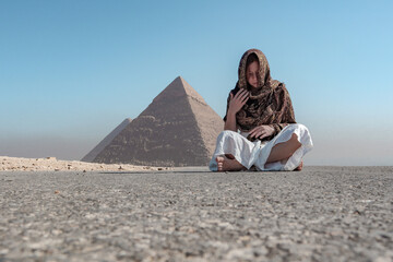 Woman sitting near the pyramids in Egypt.