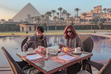 Couple enjoying breakfast with a view over the Pyramids of Giza in Caïro.