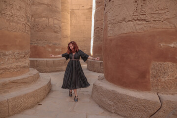 Woman between the pillars in the temple of Karnak in Luxor.