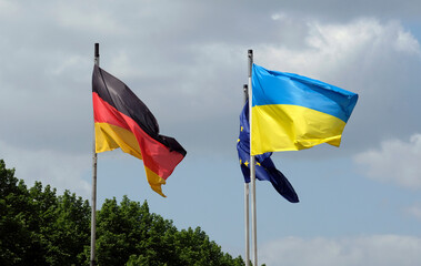 The flags of Ukraine, Germany, and the EU waving in the wind