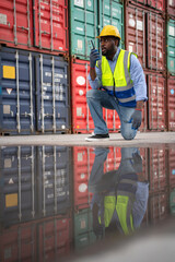 African engineer worker using radio communication and talk with staff. Reflection of the man in the water. Import and export product. Manufacturing transportation and global business concept