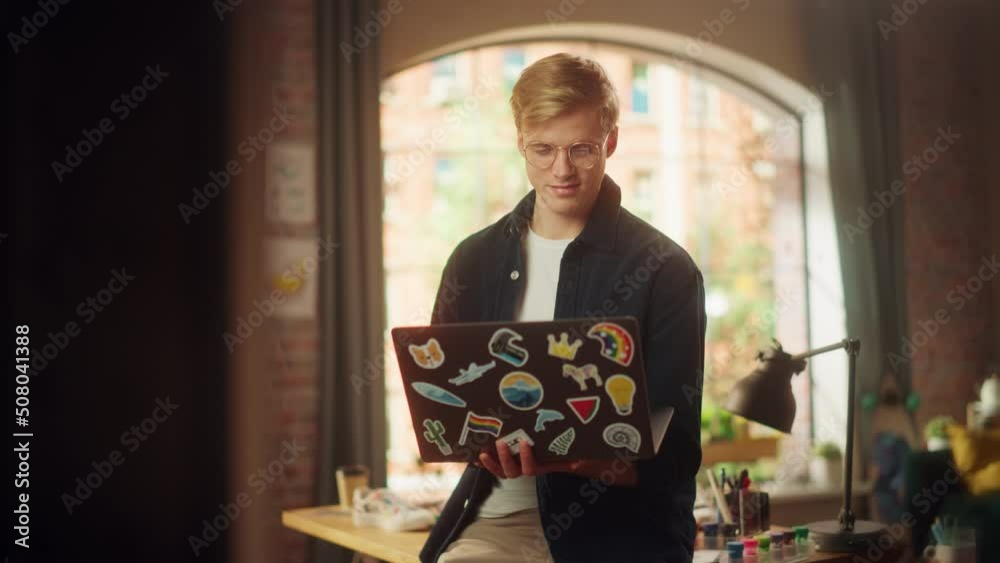 Poster positive male software engineer coding on laptop computer while working with inspiration in his stud