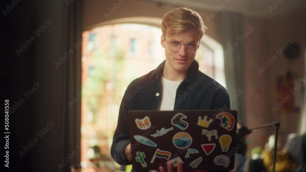 Aufkleber Stylish Person Using Laptop Computer with Diverse LGBTQ+ Stickers while Standing at Loft Studio. Creative Young Man Browsing Internet and Managing Social Media. Slow Motion Shot